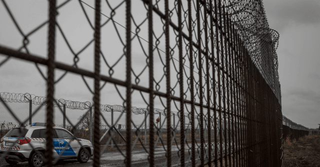 Hungarian border fence and police vihicle in view