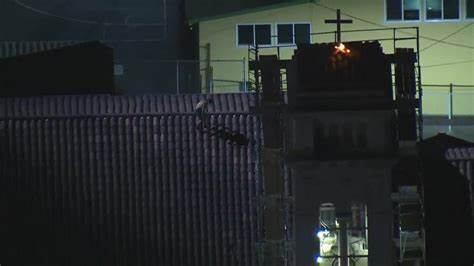 VIDEO: Man seen leaping from roof to roof accused of setting church’s cross on fire