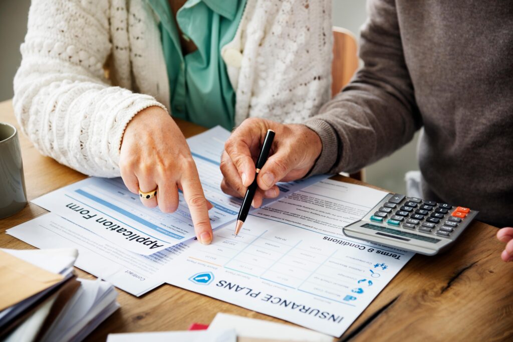 Health insurance enrollment paperwork and policy documents spread across a desk, illustrating administrative enrollment in U.S. healthcare coverage programs.