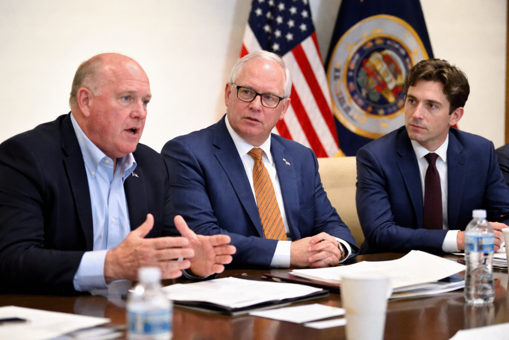 Border Czar Tom Homan meets with Minnesota Governor Tim Walz and Minneapolis Mayor Jacob Frey at a conference table, with U.S. and Minnesota flags visible during a law enforcement discussion.