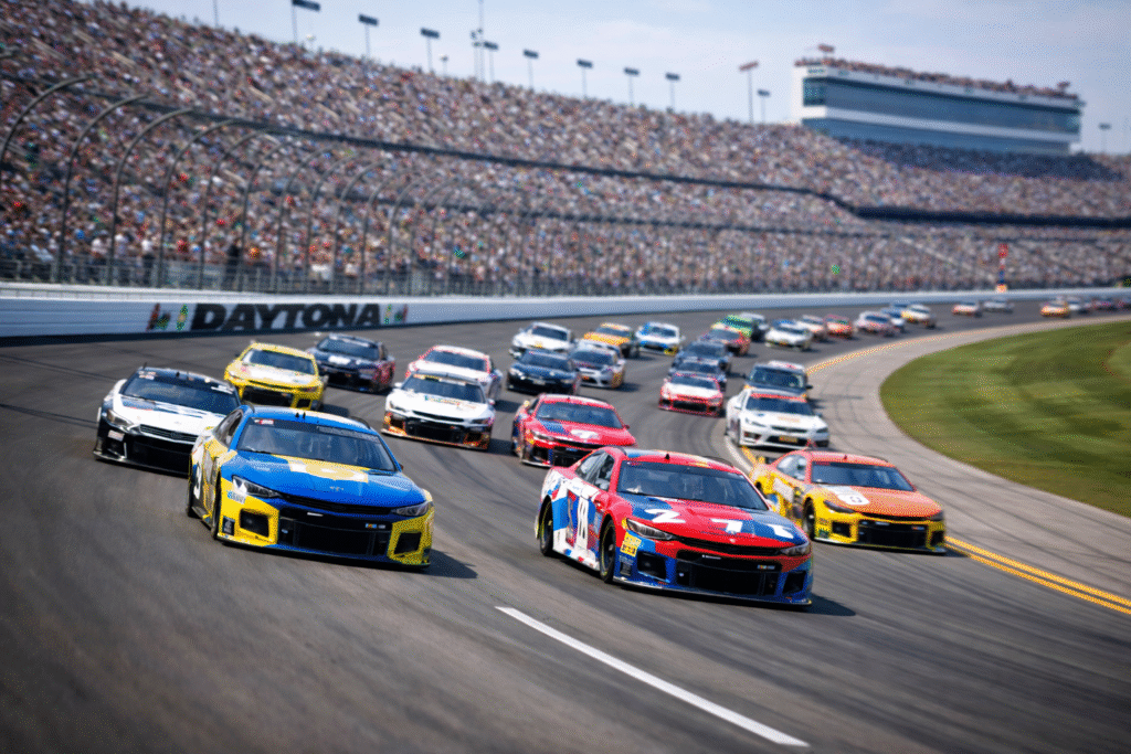 Action shot of stock cars racing around the Daytona International Speedway during a high-speed moment, capturing the excitement of the Daytona 500.